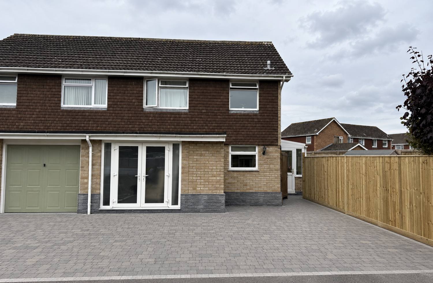 Completed block paving driveway with new timber fencing by StoneBase